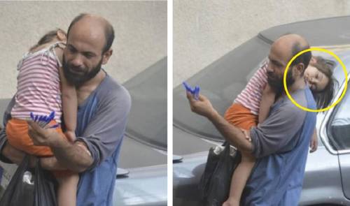 Soportando las incomodidades de la calle este hombre con su pequeña niña dea..