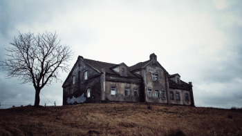 Casa abandonada con un árbol seco al lado