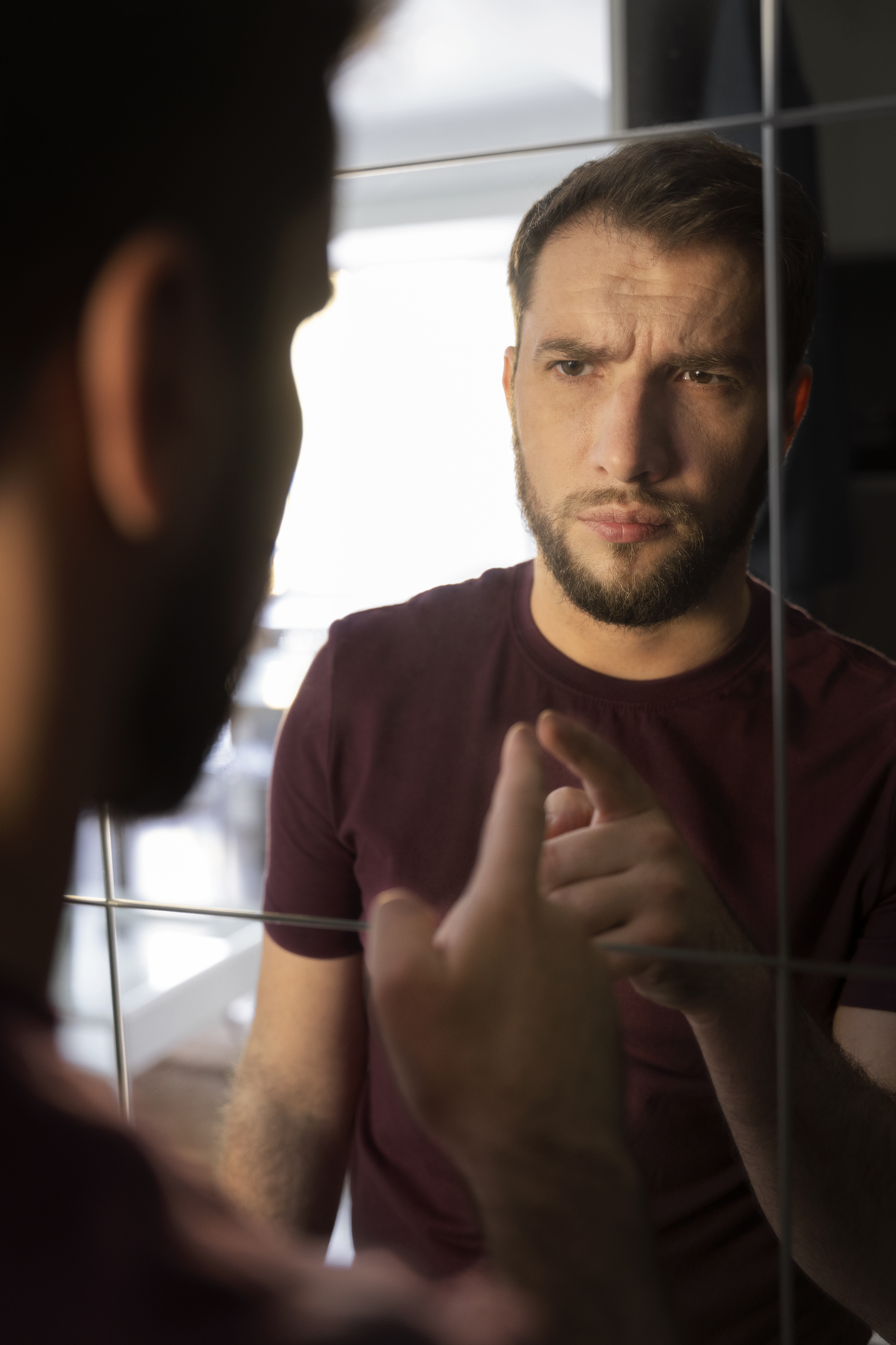 side view anxious man looking mirror