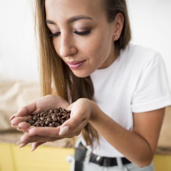 woman smelling beans from her hands woman smelling beans from her hands
