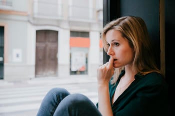 woman thinking near cafe window woman thinking near cafe window